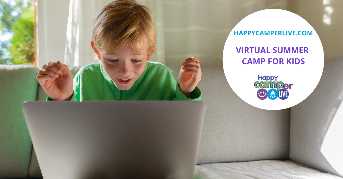 a kid having fun and smiling at the computer doing virtual summer camp for kids