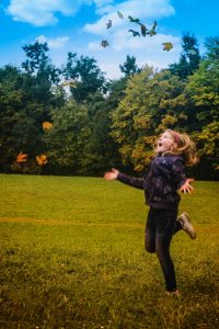 kid in fall leaves