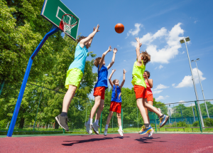 kids jumping while playing basketball