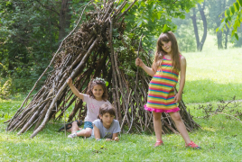 a child stands by a branch fort