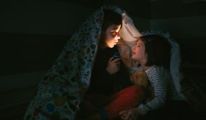 kids telling scary stories by a campfire