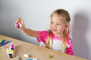 a child holds up a craft