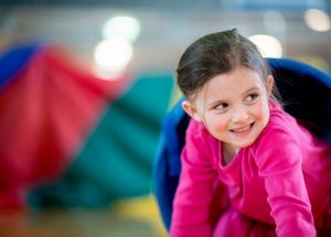 a girl crawls out of a tunnel